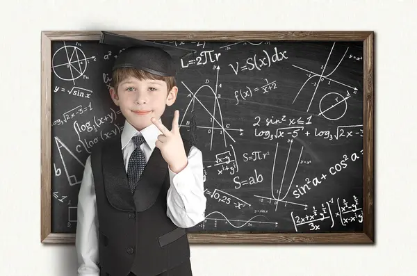 Boy near blackboard with formulas