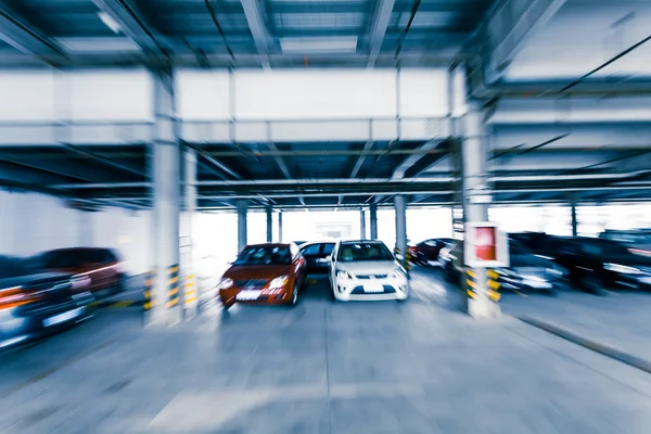Parking garage, interior with a few parked cars.Motion blur