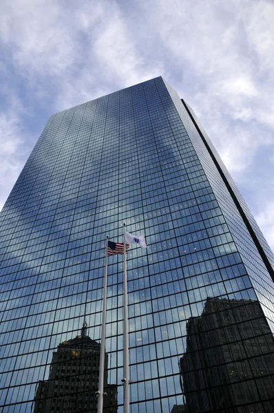 John Hancock Tower, Boston, with buildings and the American flag reflecting in the glass windows