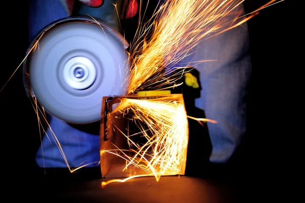 Worker cutting metal with grinder