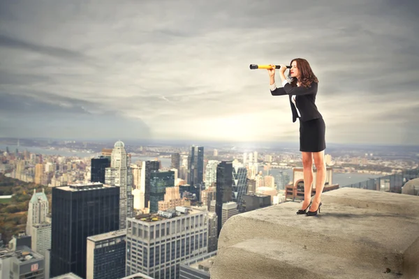 Business woman looking through a binoculars