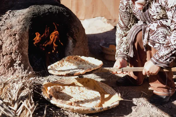 Baking traditional bread in a natural clay oven in rural Morocco