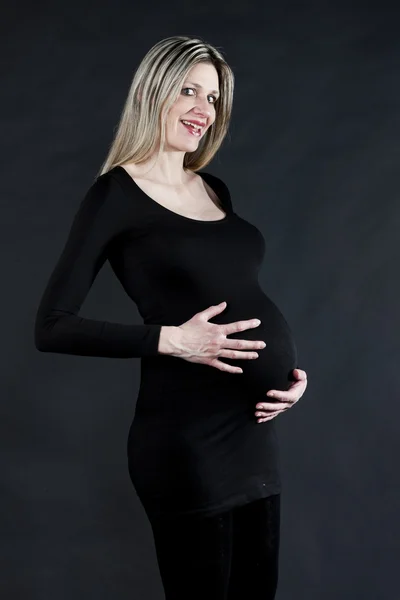 Portrait of pregnant woman wearing black clothes