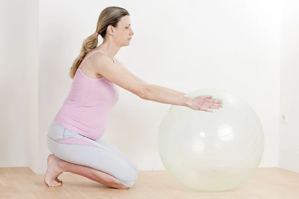 Pregnant woman doing exercises with a ball