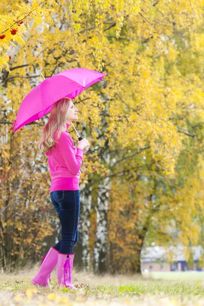 Woman wearing rubber boots with umbrella