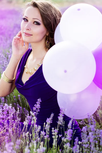 Adorable girl with purple balloons.