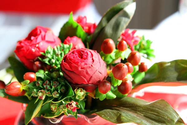 Vase of red flowers on a red tablecloth