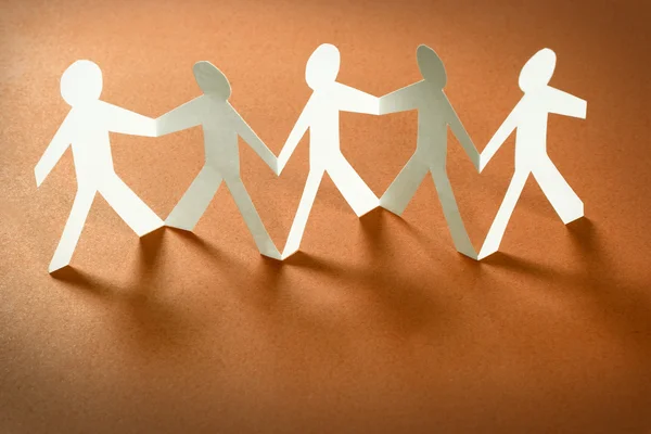 Group of paper people holding hands. Teamwork concept