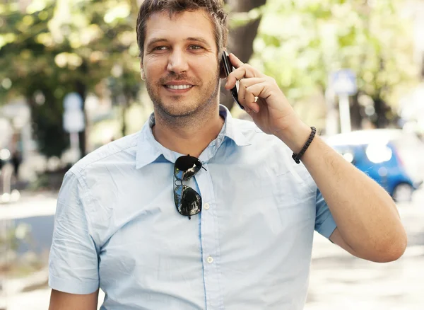 Young businessman drinking coffee and speaking on the phone