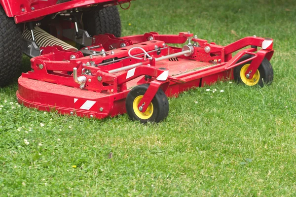 Lawnmower cuts a green lawn