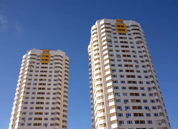 Two new constructed buildings over clear blue sky