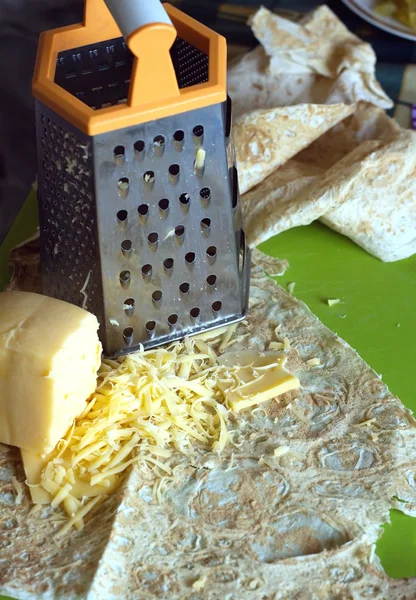 Cooking on kitchen desk. Grater, pita bread and sliced cheese