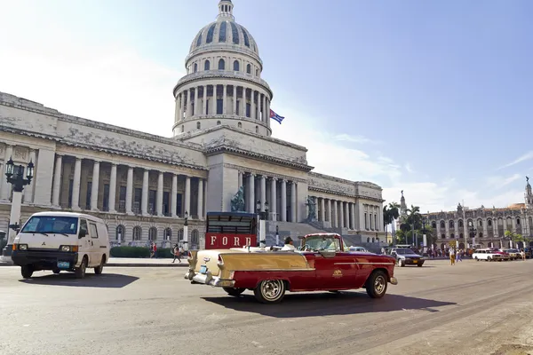 Old cars running and parked in front of the Capitol