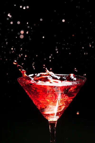 Red splashing cocktail on black