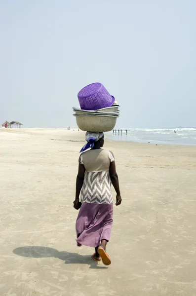 A woman from Ghana African nest on his head heavy load.