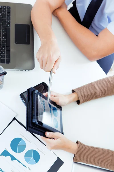 Executive hands with digital tablet in a financial meeting