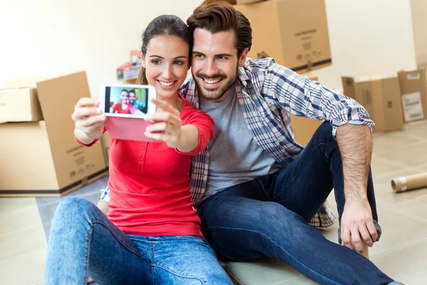 Young couple taking selfies in their new home