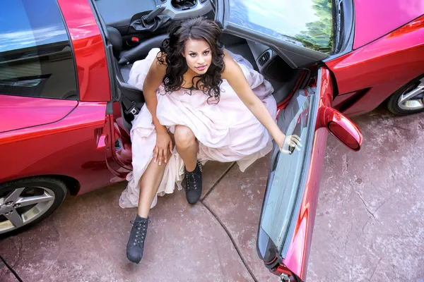 Beautiful Young African American Woman in a Fast Red Car