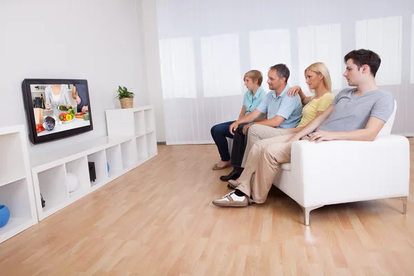 Family watching widescreen television