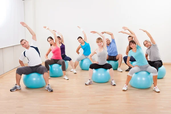 pilates class exercising in a gym