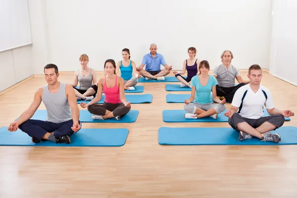 Group of practicing yoga meditating