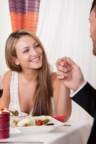 Man holding a woman\'s hand at a romantic dinner