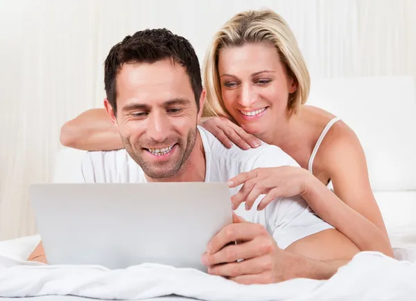 Young couple reading a laptop screen