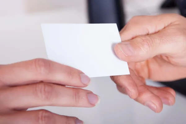 Man handing a woman a business card — Stock Photo #17392151