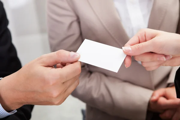 Businesspeople exchanging cards over coffee