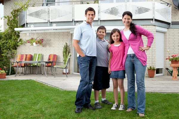 Young family standing in front of their house