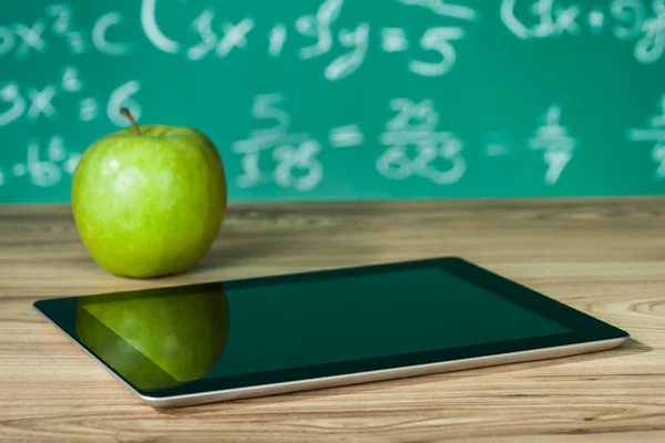 Digital tablet and apple on the desk