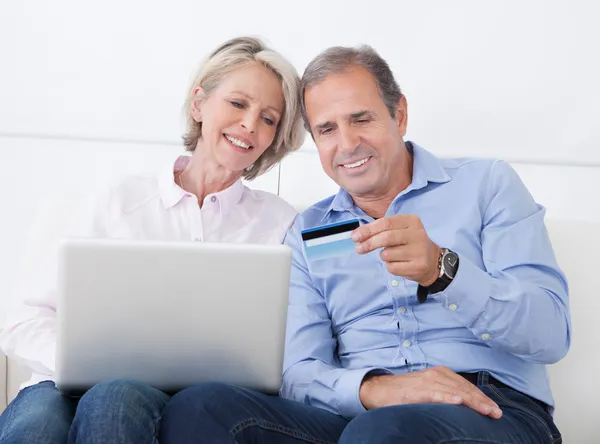 Happy Mature Couple Shopping On Laptop