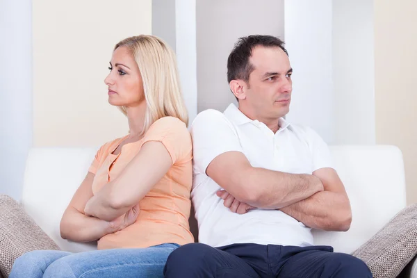 Angry couple sitting on sofa