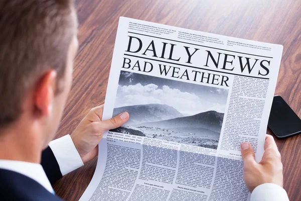 Close-up Of Businessman Reading Weather News