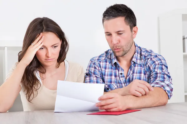 Worried Couple Reading Paper