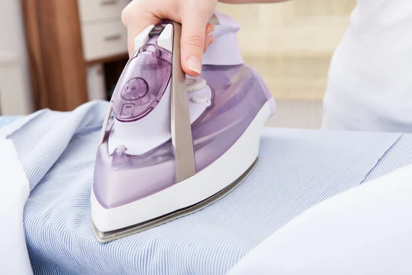Person Ironing Clothes