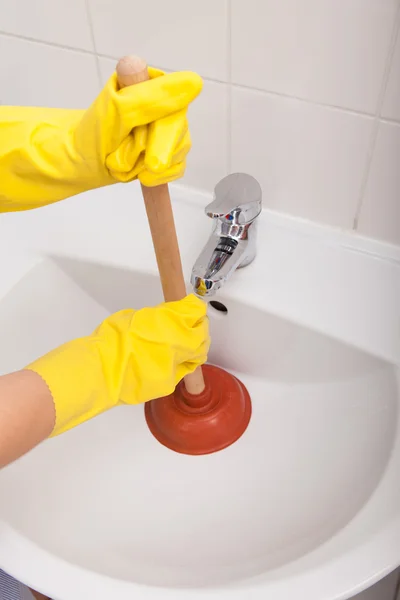 Person\'s Hand Pressing Plunger In Sink