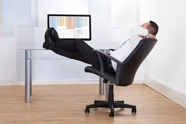 Relaxed Businessman Sitting Feet Up At Desk