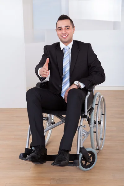 Businessman In Wheelchair Offering Handshake