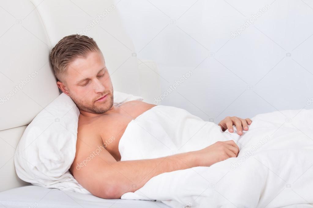 Man sleeping in bed propped up against the pillows — Stock Photo