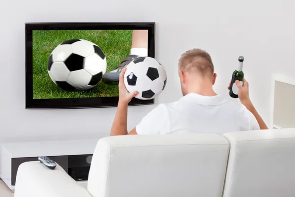 Excited soccer fan watching a game on television
