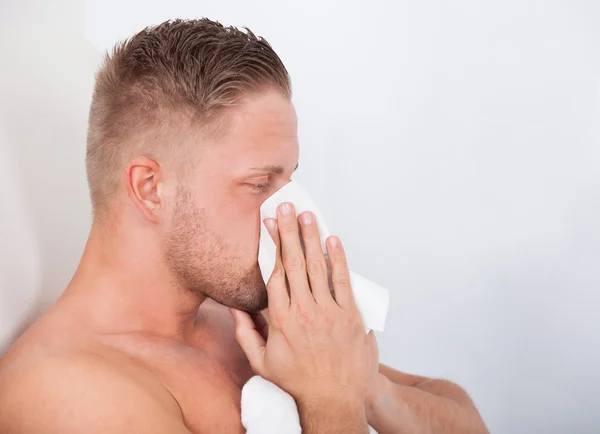 Man with a cold blowing his nose