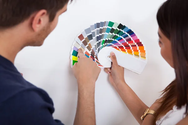 Couple Choosing Color For Wall At New Home