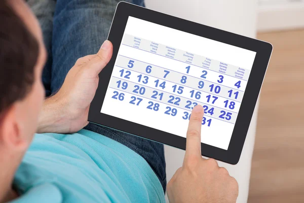 Man Using Calendar On Digital Tablet
