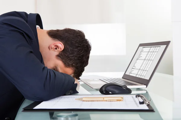 Tired Businessman Sleeping While Calculating Expenses In Office