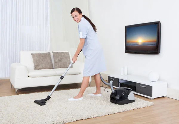 Maid Cleaning Carpet With Vacuum Cleaner