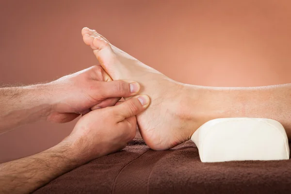 Therapist Giving Foot Massage To Female Customer At Spa