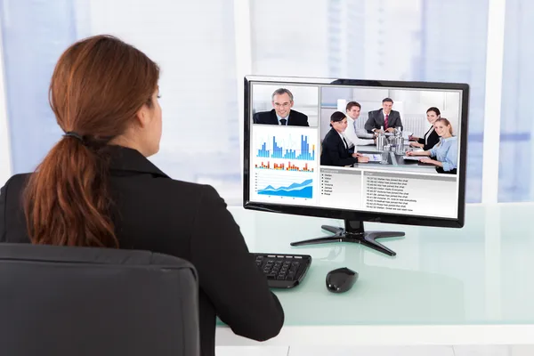 Businesswoman Video Conferencing With Team On Computer