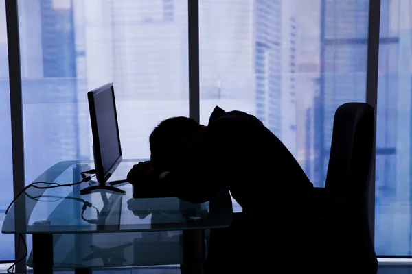 Businessman Sleeping At Computer Desk