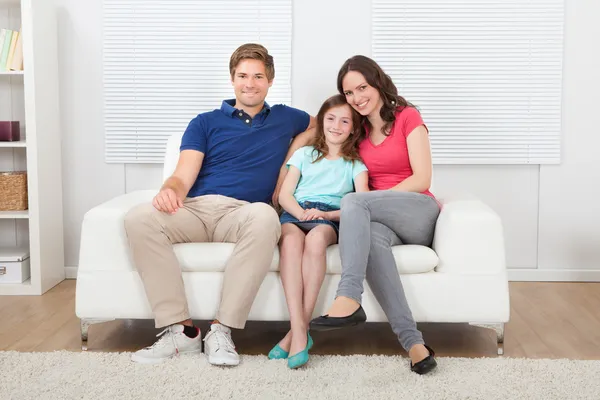 Family Sitting On Sofa